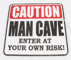 A cast iron sign 'Caution Man Cave - Enter at your own risk!', 25 x 24cm