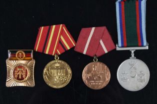 A collection of three East German medals to include Good Team Work (1967-1970), For Services