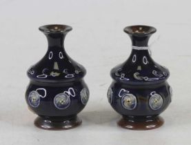 A pair of Royal Doulton miniature stoneware vases, each having a flared rim to bulbous body, tube-