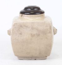 A Chinese crackle glazed pottery jar, having a wooden lid and flanked by mask handles, h.17cm