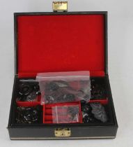 A black faux leather clad jewellery box containing various pieces of carved Whitby jet etc.