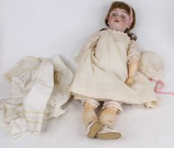 A vintage German Handwerck Halbig bisque headed doll having rolling eyes and four upper teeth,