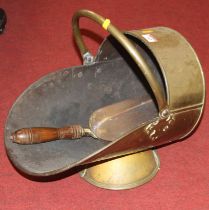 A Victorian helmet shaped copper coal scuttle, together with a shovel