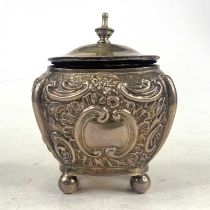 A Victorian silver tea caddy, of bombe shape, repousse decorated with scrolls and flowers, on bun