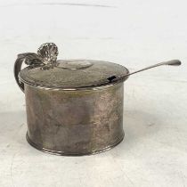 A 19th century silver mustard, of cylindrical shape, having a shell shaped thumbpiece and scroll