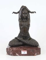 A bronzed figure of a lady, shown in yoga pose, mounted upon a red polished hardstone plinth, h.30cm