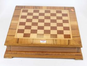 A walnut and maple veneered chessboard, the board lifting to reveal storage beneath, 42 x 42cm