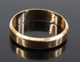 A yellow metal wedding band, of plain undecorated form, stamped K14 and tests as approximately 14