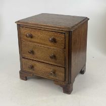 A Victorian style oak apprentice round corner chest, containing three long drawers, on bracket feet,