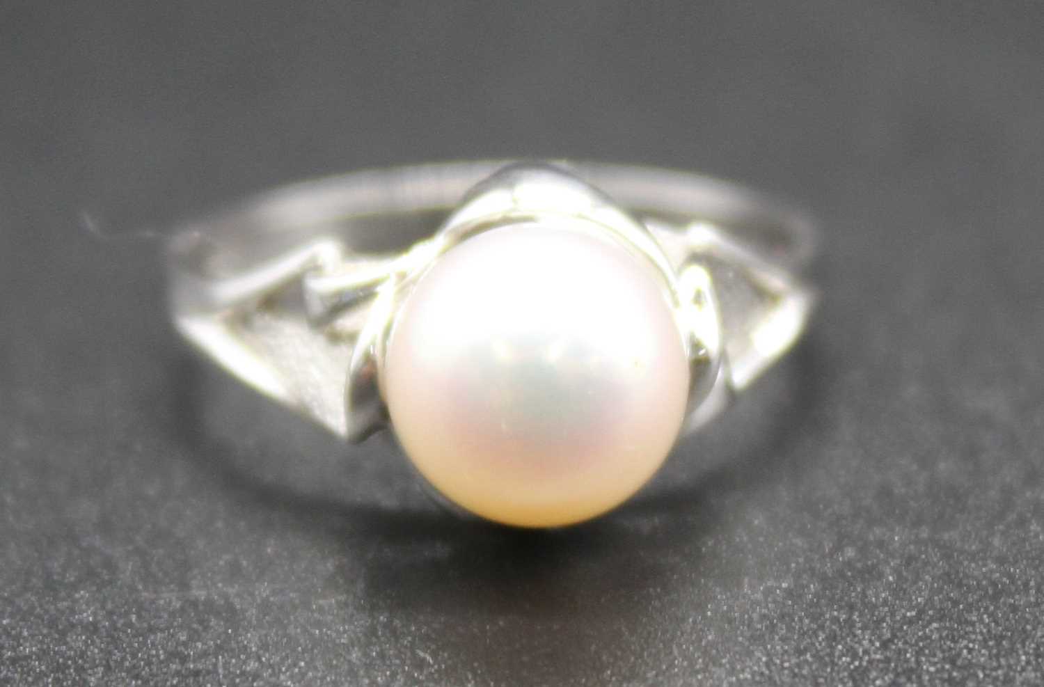 A modern white metal and cultured pearl set dress ring, pearl dia. approx 8.5mm, on a raised and