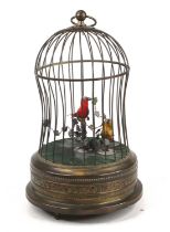 A brass birdcage automata, containing two birds, the case with repousse decoration, h.27cm A bit