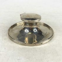 A George V silver capstan inkwell, of circular shape on a weighted base, engraved "In memory of your