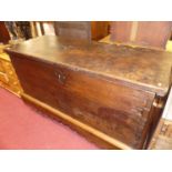 An 18th century rustic oak and elm hinge top chest, of imposing proportions with exposed finger
