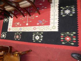 A Caucasian woollen red and black ground Kelim rug, with stylised floral motifs, 344 x 253cm