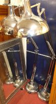 A pair of contemporary polished chromed metal angle poise floor lights, with domed shades, each