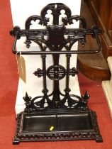 A black painted cast iron pierced stick stand, with integral drip tray, in the Victorian taste, 70.5