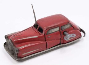 A Joustra pre-war No. 2002 tinplate and clockwork car comprising of red tin printed body with
