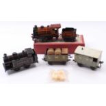 Small tray containing a ‘mixed bag’ of 0-gauge items: Brimtoy 0-4-0 clockwork loco & tender no.7000,