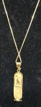 A middle eastern high carat gold pendant decorated with hieroglyphics on 18ct gold trace link