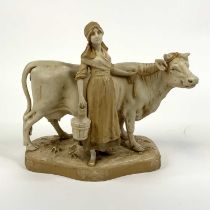 A Royal Dux porcelain figure of a milk maid beside a cow, height 27cm Minor chips to the plinth,