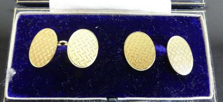 A Goldsmiths & Silversmiths Company Ltd cased pair of gent's 18ct gold oval cufflinks, with engine