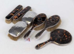 A George V silver and tortoiseshell clad five-piece dressing table set, comprising two clothes