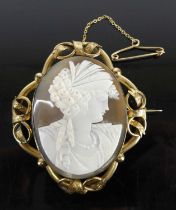 A carved shell cameo portrait brooch, in pierced pinchbeck mount with closed back, circa 1900,