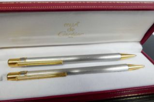 A boxed Must de Cartier ballpoint pen, serial number C19272, in fitted red leather case; together