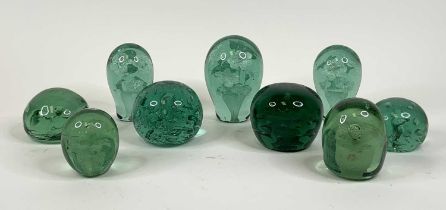 A collection of nine Victorian green glass dump paperweights, largest height 13cm The larger squat