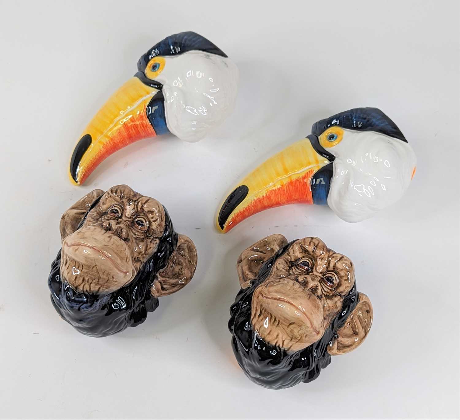 A pair of novelty wall pockets in the form of toucans, height 13cm, together with another pair in