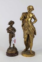 *A gilt painted spelter figure of a boy playing the bagpipes mounted to a circular rouge marble