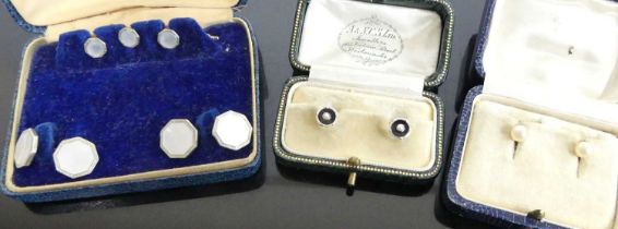 A cased pair of yellow metal, black onyx and seed pearl set collar studs; together with a pair of