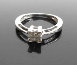 A modern white metal diamond cluster ring, arranged as four Princess cuts in a square setting, total