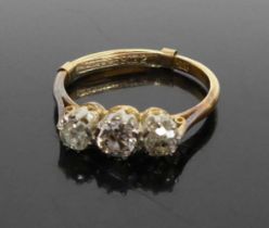An 18ct gold diamond three stone ring arranged as three old round cuts in a line setting, total