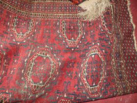 A Persian style red ground machine-woven Bokhara rug; together with a further Persian red ground