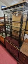 *A contemporary Oriental black lacquered and gilt decorated display cabinet, having twin bevelled