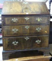 *A George III walnut cross and feather banded slope front writing bureau, having a fitted interior