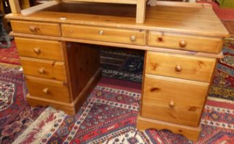 A modern pine round cornered kneehole desk, w.137cm