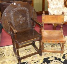 An early 20th century oak monks seat, having a circular fold-over top, floral relief decoration to