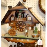 *A contemporary carved wood Swiss cuckoo wall clock, with three weights