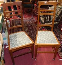 A pair of Arts & Crafts oak ladder back dining chairs, each having stylised green fabric floral