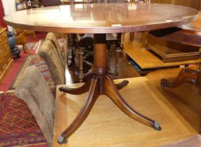 A contemporary mahogany fixed top circular pedestal centre table, raised on outswept supports to