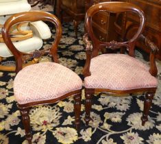 A set of eight Victorian style mahogany balloon back dining chairs, each with floral fabric stuff