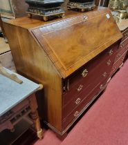 An early 19th century mahogany slopefront writing bureau, having a fitted interior over four long