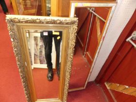 A gilt composition framed and bevelled rectangular wall mirror, 121 x 50cm; together with a modern