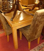 A contemporary blond oak drawleaf dining table, raised on square block supports; together with a set