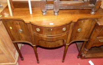 A circa 1900 mahogany serpentine front compact sideboard, having an arrangement of three drawers and