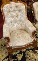 A mid-Victorian oak framed scroll armchair, having silk needlework floral button back upholstery