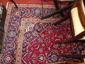 A Persian red and blue ground Tabriz rug, the heavy floral central ground with conforming tramline