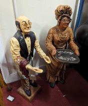 A painted resin standing model of a butler, and another holding a Welcome tray, the larger h.98cm (